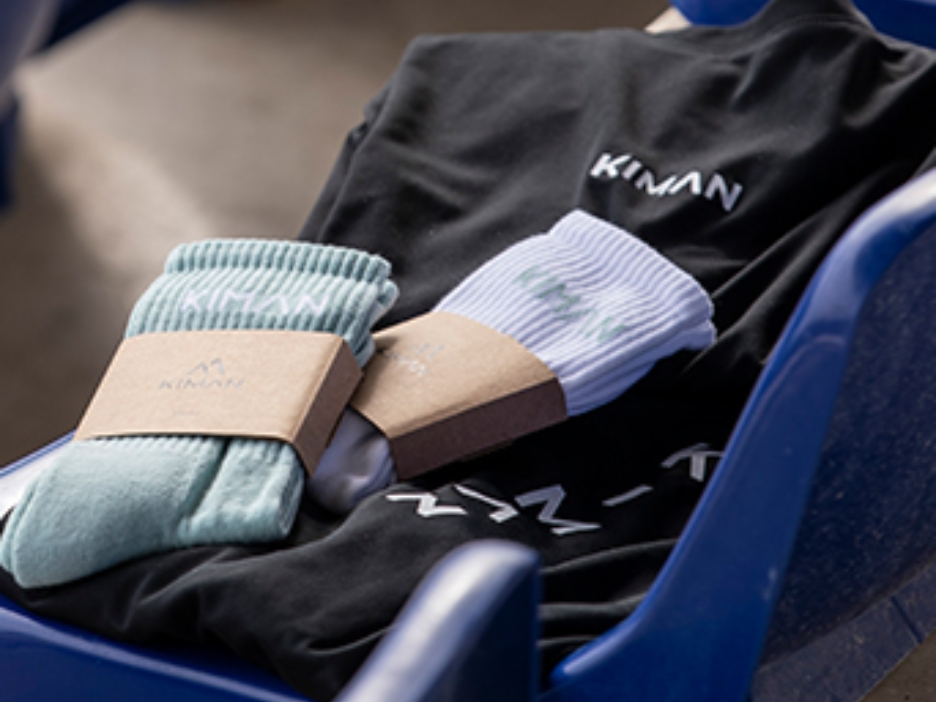 Produkte der Sportartikel Firma Kiman Sport liegen auf einer blauen Sitzschale einer Tribüne