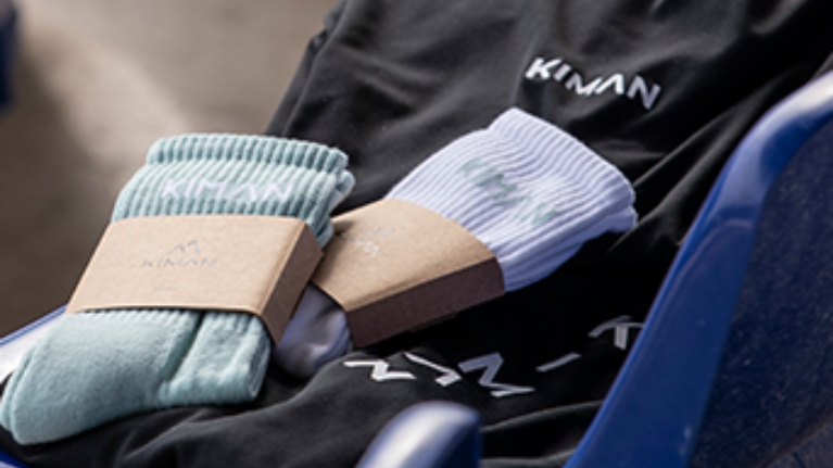 Produkte der Sportartikel Firma Kiman Sport liegen auf einer blauen Sitzschale einer Tribüne